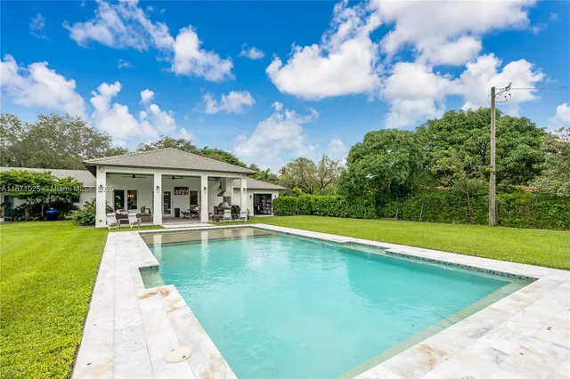 a living room with patio furniture and a floor to ceiling window