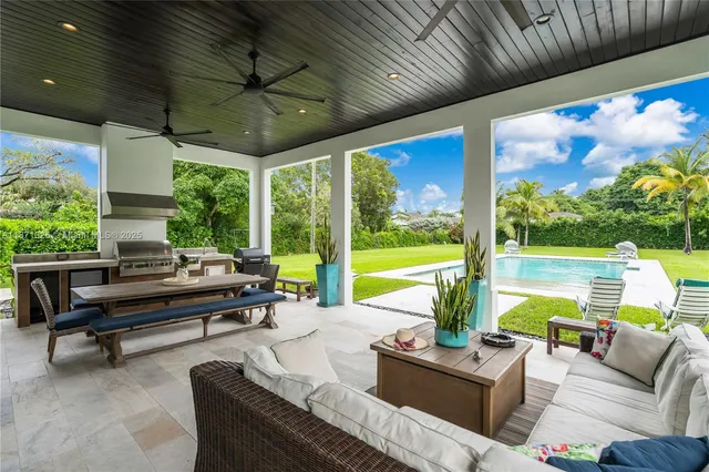 a view of a patio with a dining table and chairs with a wooden floor and yard