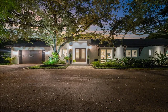 an aerial view of residential houses with outdoor space and trees