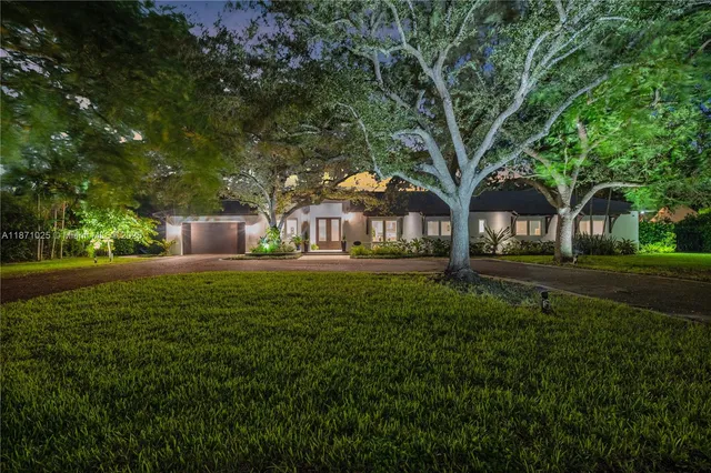 an aerial view of residential houses with outdoor space and trees