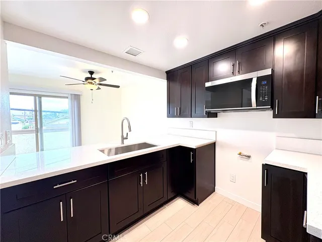 a large bathroom with a sink a large mirror and a view of kitchen