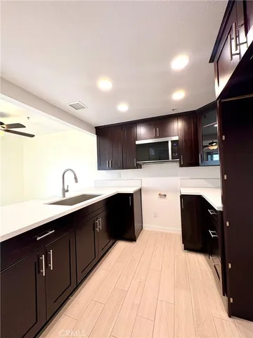 a view of a livingroom with a ceiling fan and kitchen view