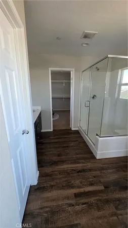 a view of a hallway with wooden floor and entryway