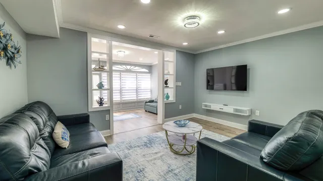 a living room with furniture a flat screen tv and a large window