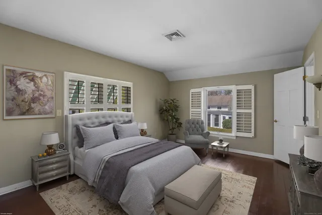 a bedroom with a bed couch and a large window