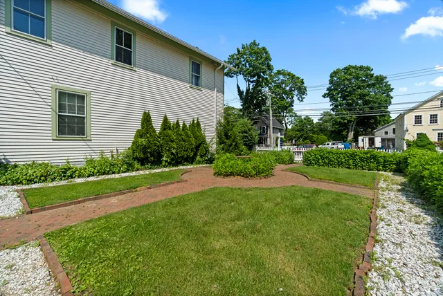 a front view of a house with a yard and potted plants