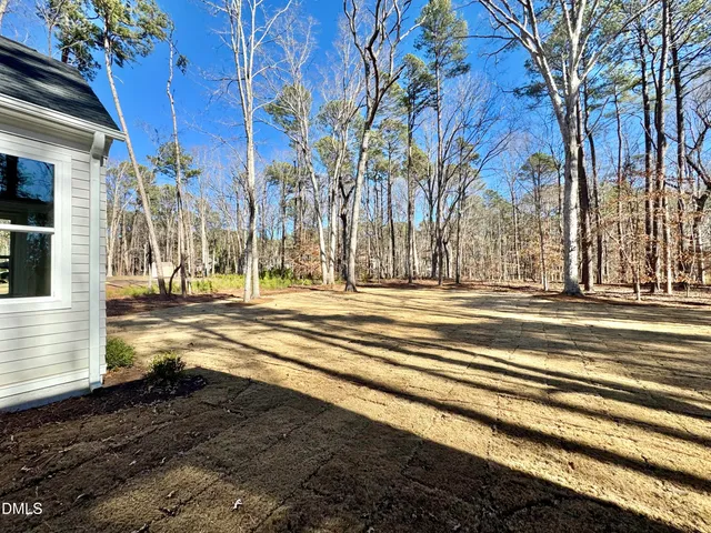 a view of a livingroom with wooden floor a fireplace and windows