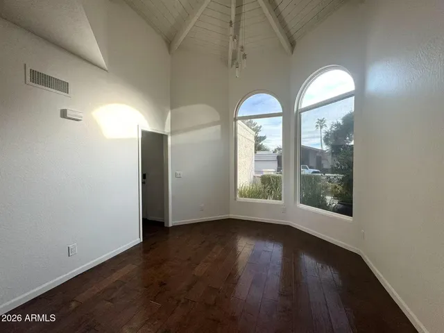 an empty room with wooden floor windows and outdoor view