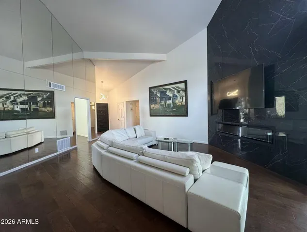 a living room with furniture and a wooden floor