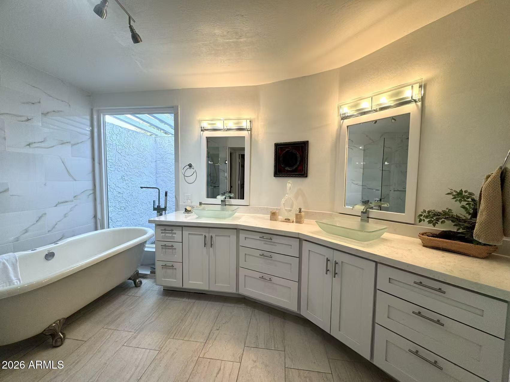 7330 East Griswold Road Scottsdale, AZ 85258 - Photo 4 of 16 a spacious bathroom with a double vanity sink mirror and bathtub