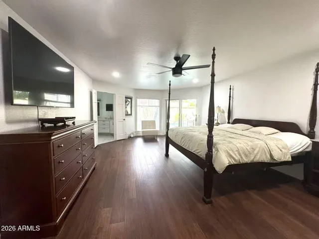 a spacious bedroom with a bed and wooden floor