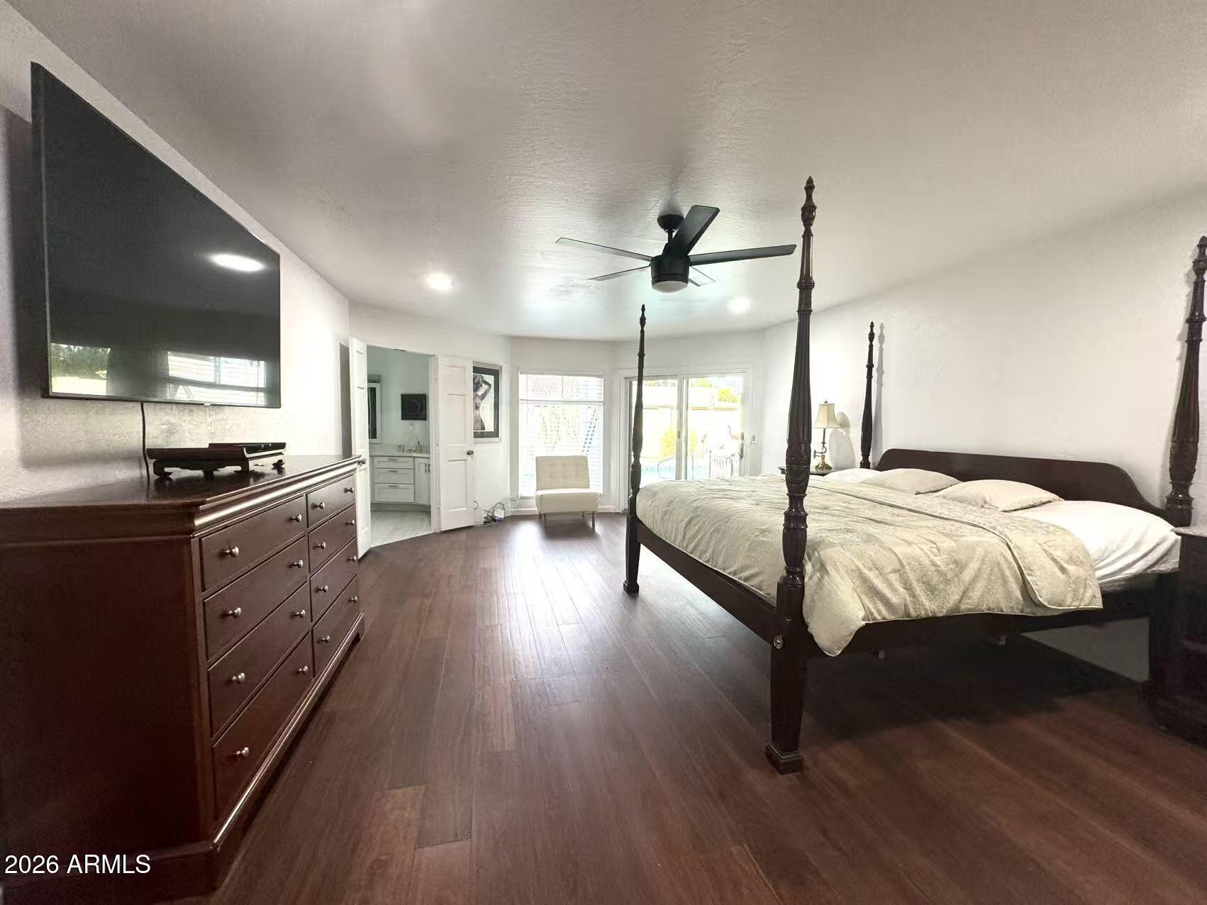 7330 East Griswold Road Scottsdale, AZ 85258 - Photo 5 of 16 a spacious bedroom with a bed and wooden floor
