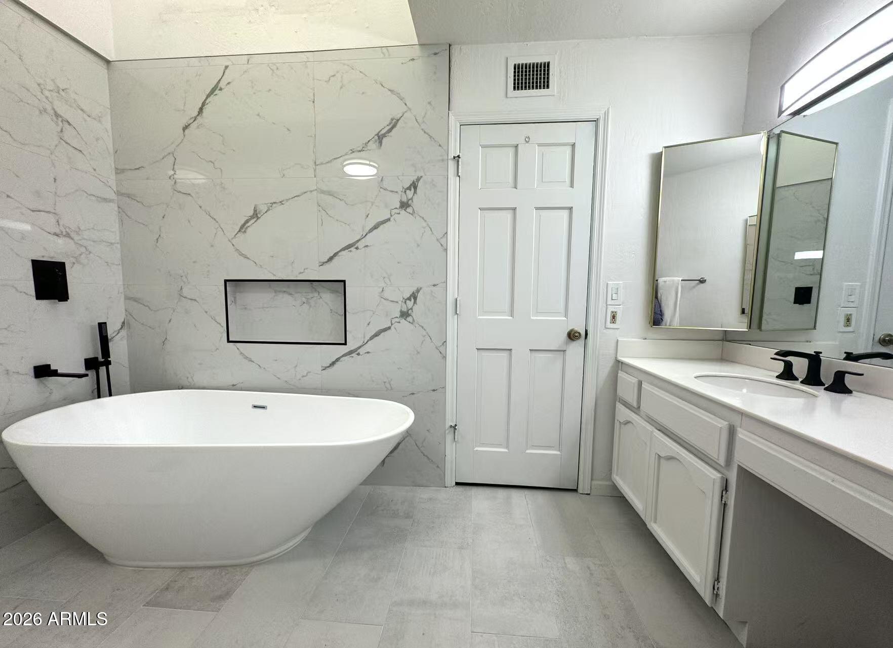 7330 East Griswold Road Scottsdale, AZ 85258 - Photo 8 of 16 a spacious bathroom with a tub sink and mirror