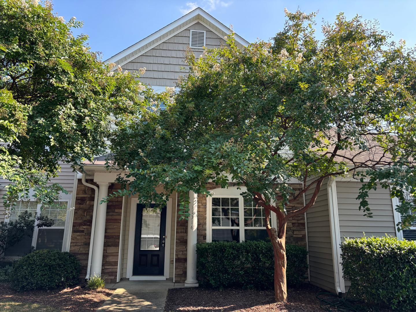front view of a house with a tree