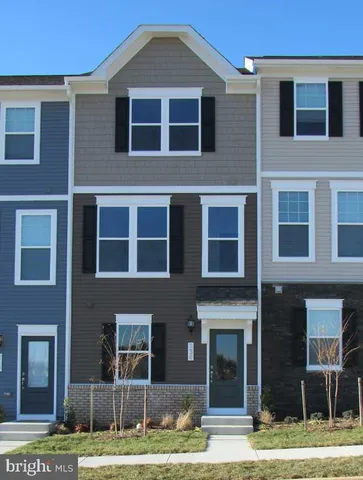 a front view of a house with yard and parking