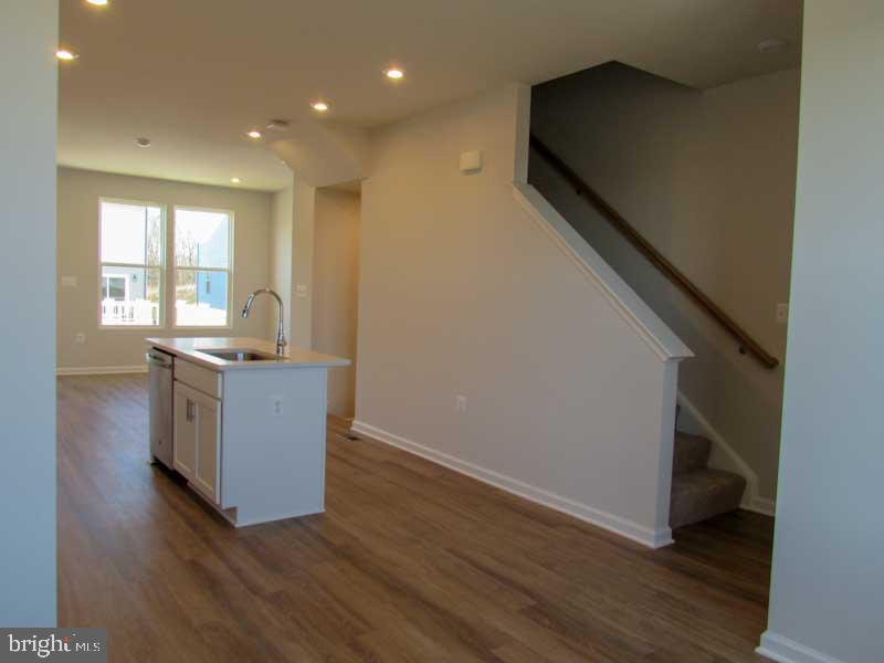 236 Anthem Street Ranson, WV 25438 - Photo 12 of 17 a living room with stainless steel appliances kitchen island granite countertop wooden floors and sink