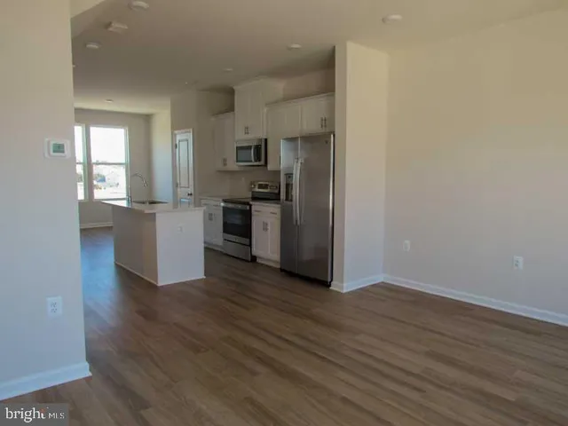 a kitchen with a refrigerator and a stove top oven
