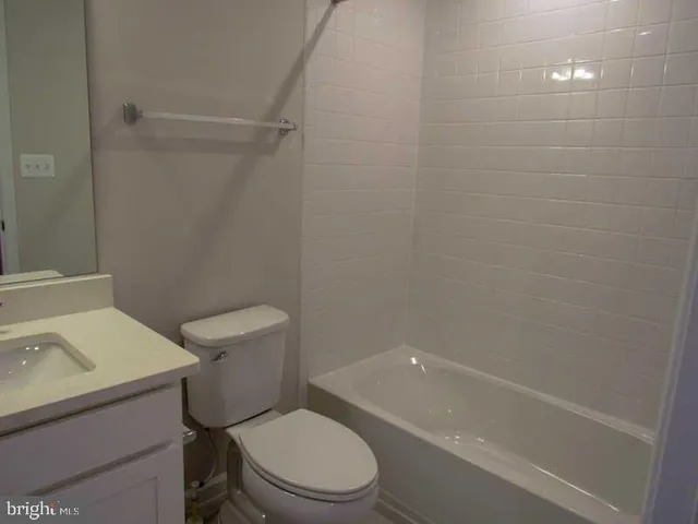 a white toilet sitting next to a bath tub
