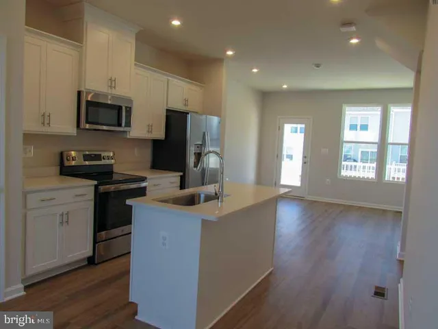 a kitchen with stainless steel appliances a refrigerator stove microwave and sink