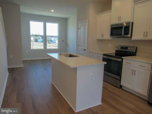 a kitchen with a stove a sink and a microwave