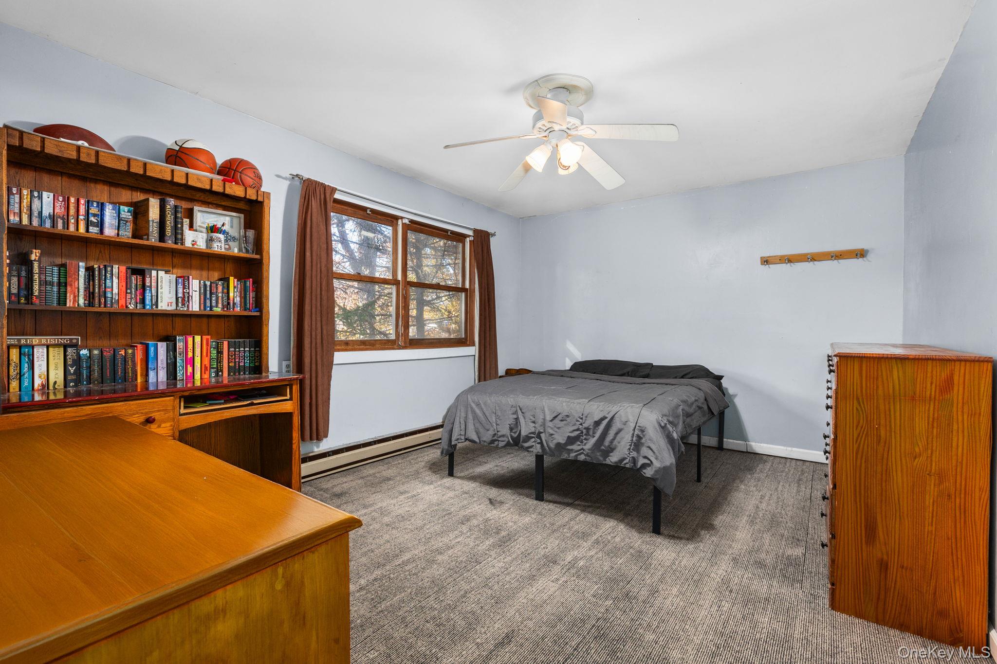 104 Riley Road New Windsor, NY 12553 - Photo 19 of 35 a spacious bedroom with a bed and a book shelf