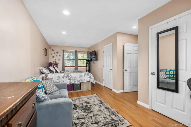 a large bedroom with a bed and wooden floor
