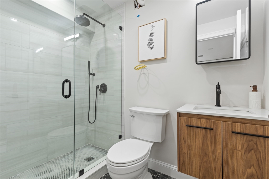 166 Salem Street, Unit A Boston, MA 02113 - Photo 11 of 16 a bathroom with a granite countertop toilet sink and shower