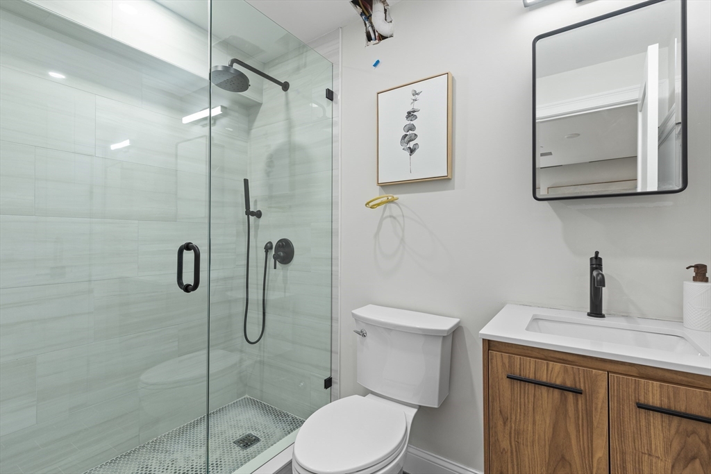166 Salem Street, Unit A Boston, MA 02113 - Photo 12 of 16 a bathroom with a toilet a sink a shower and mirror