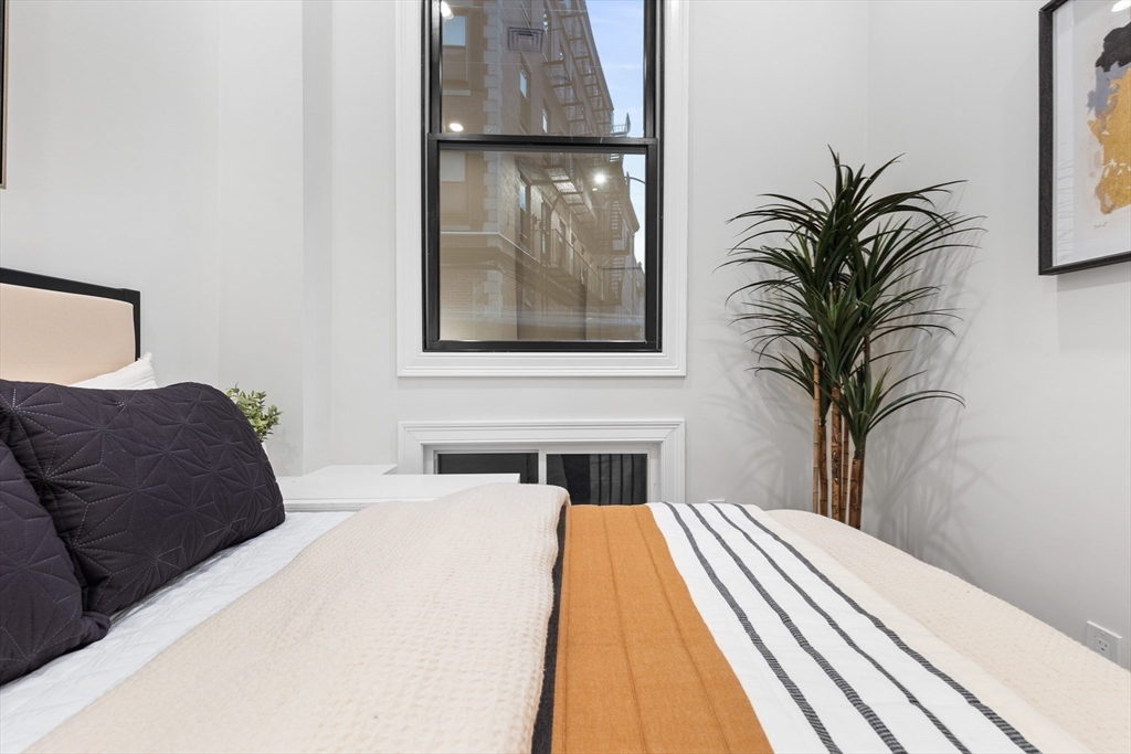 166 Salem Street, Unit A Boston, MA 02113 - Photo 14 of 16 a bedroom with a large bed and a painting on the wall