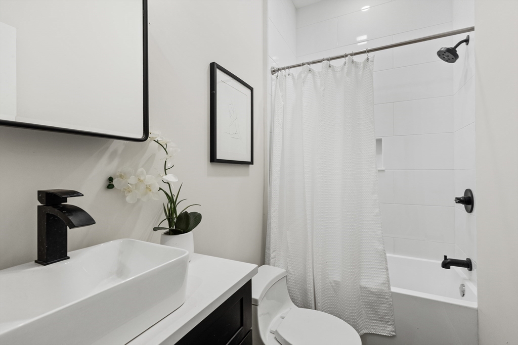 166 Salem Street, Unit A Boston, MA 02113 - Photo 15 of 16 a bathroom with a sink a toilet and shower curtain