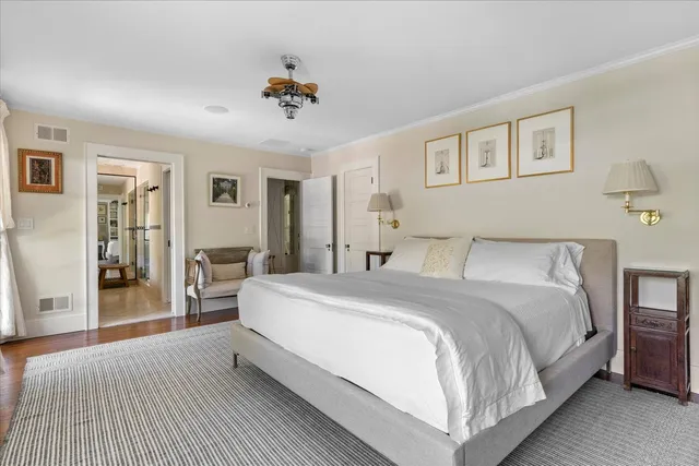 a spacious bedroom with a bed and wooden floor