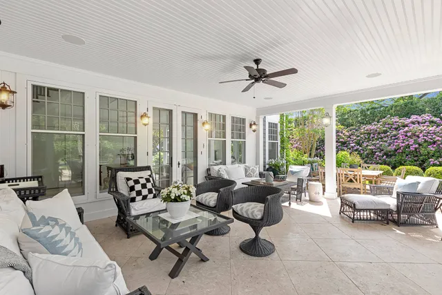 a living room with furniture and floor to ceiling windows