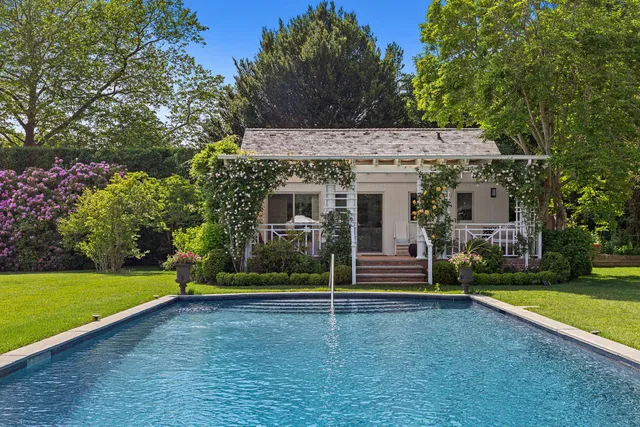 a front view of a house with a garden and trees