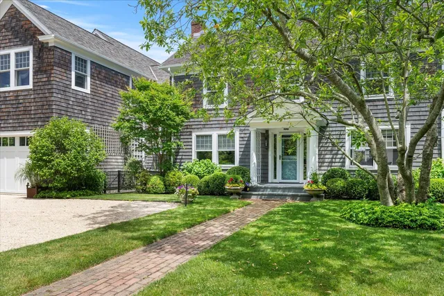 a front view of a house with yard and green space