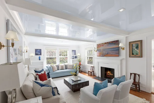 a living room with furniture fireplace and a large window