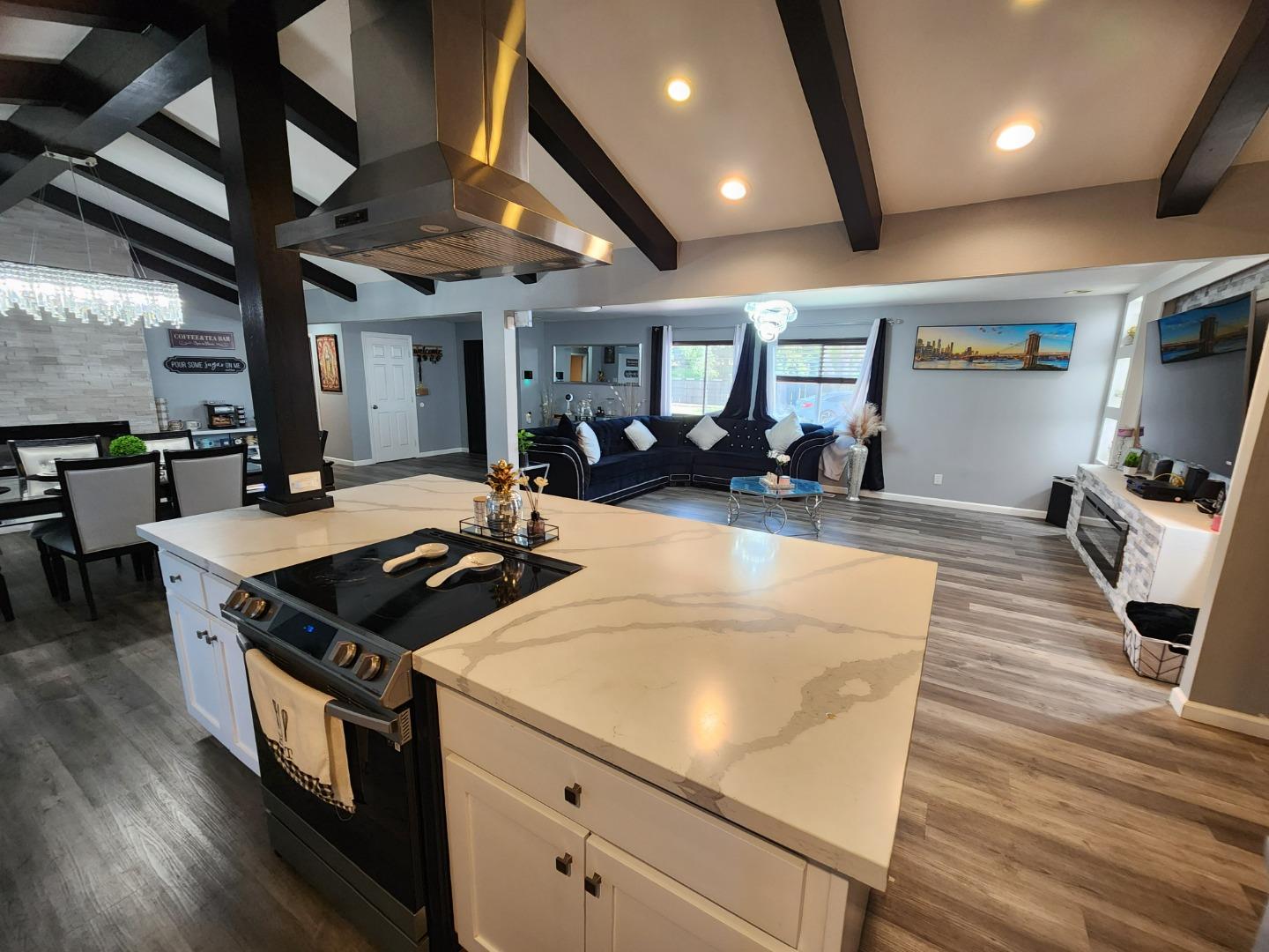 601 Weyer Road Modesto, CA 95357 - Photo 7 of 27 a kitchen with stainless steel appliances granite countertop a stove and a wooden floors