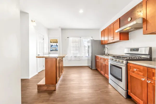 a kitchen with stainless steel appliances granite countertop a stove a sink and a refrigerator