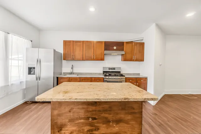a kitchen with stainless steel appliances granite countertop a sink stove and refrigerator