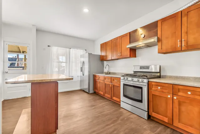 a kitchen with stainless steel appliances granite countertop a stove a sink and a refrigerator