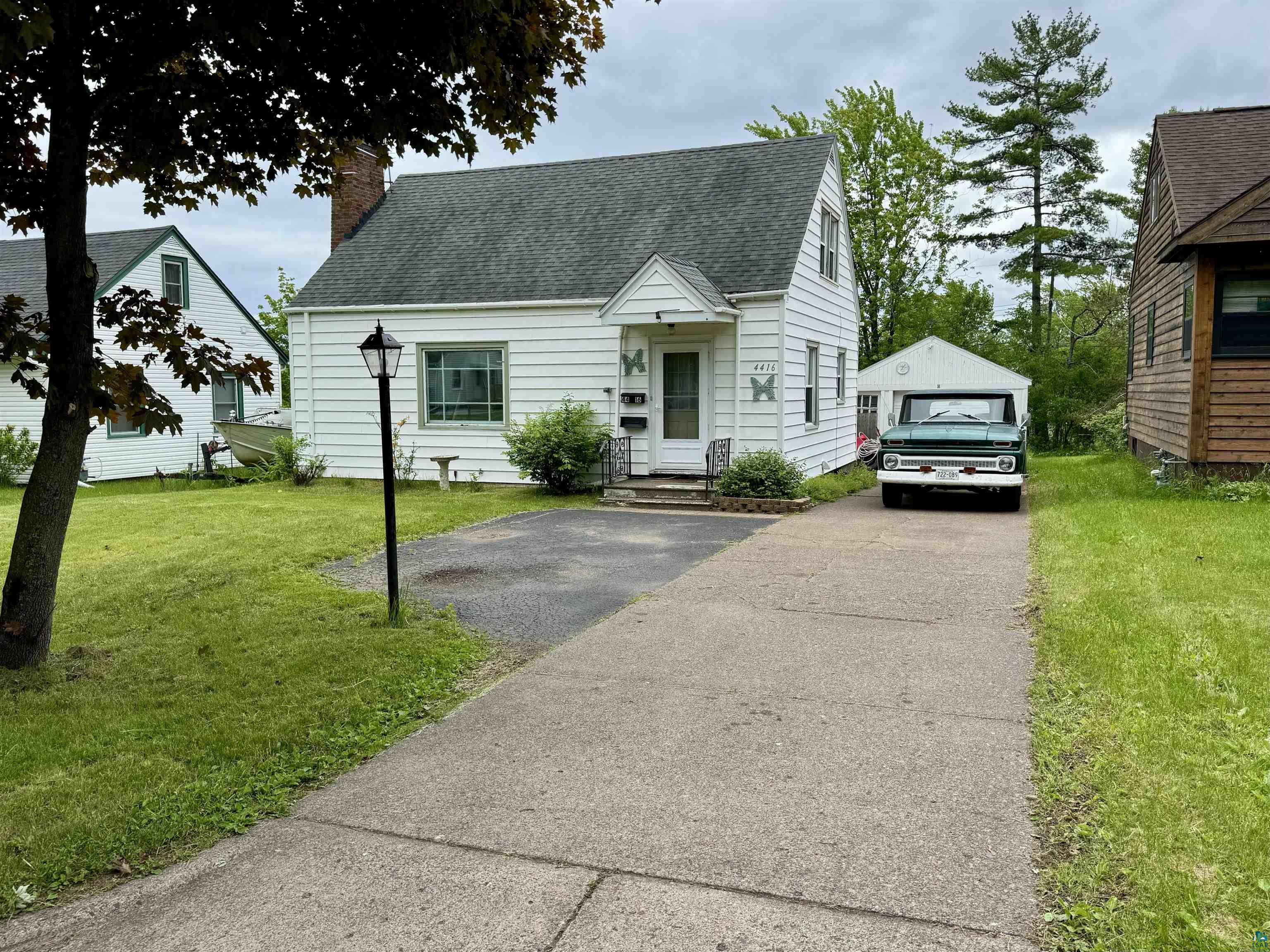 4416 Oneida Street Duluth, MN 55804 - Photo 1 of 12 Cape cod house featuring a front yard, an outdoor structure, and a garage