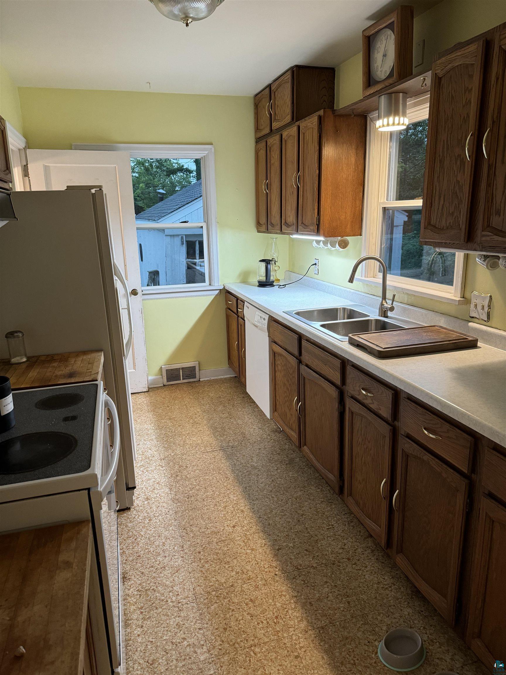 4416 Oneida Street Duluth, MN 55804 - Photo 11 of 12 Kitchen featuring dishwasher, sink, dark brown cabinets, and range