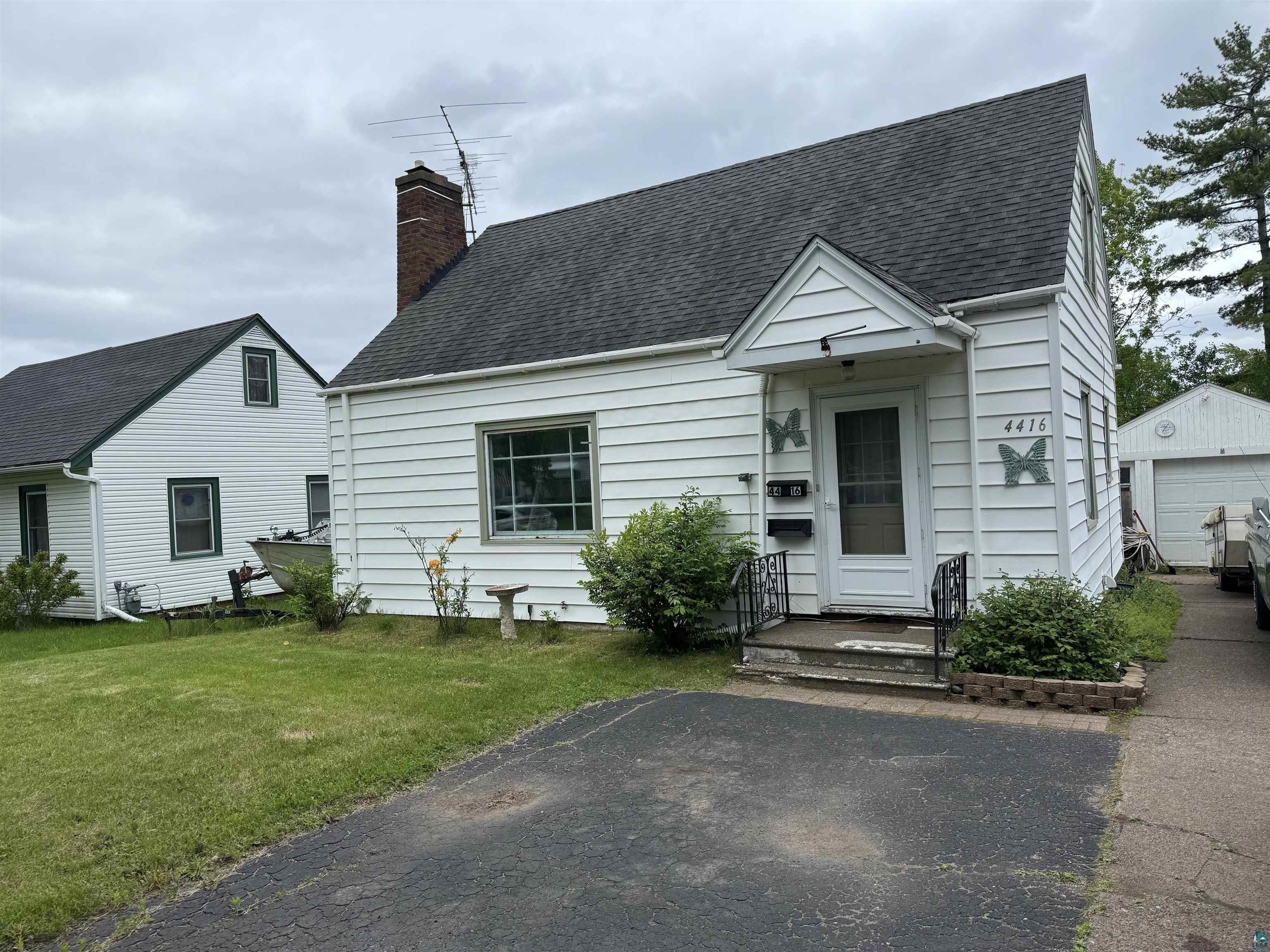 4416 Oneida Street Duluth, MN 55804 - Photo 2 of 12 View of front facade featuring a garage, a front lawn, and an outdoor structure
