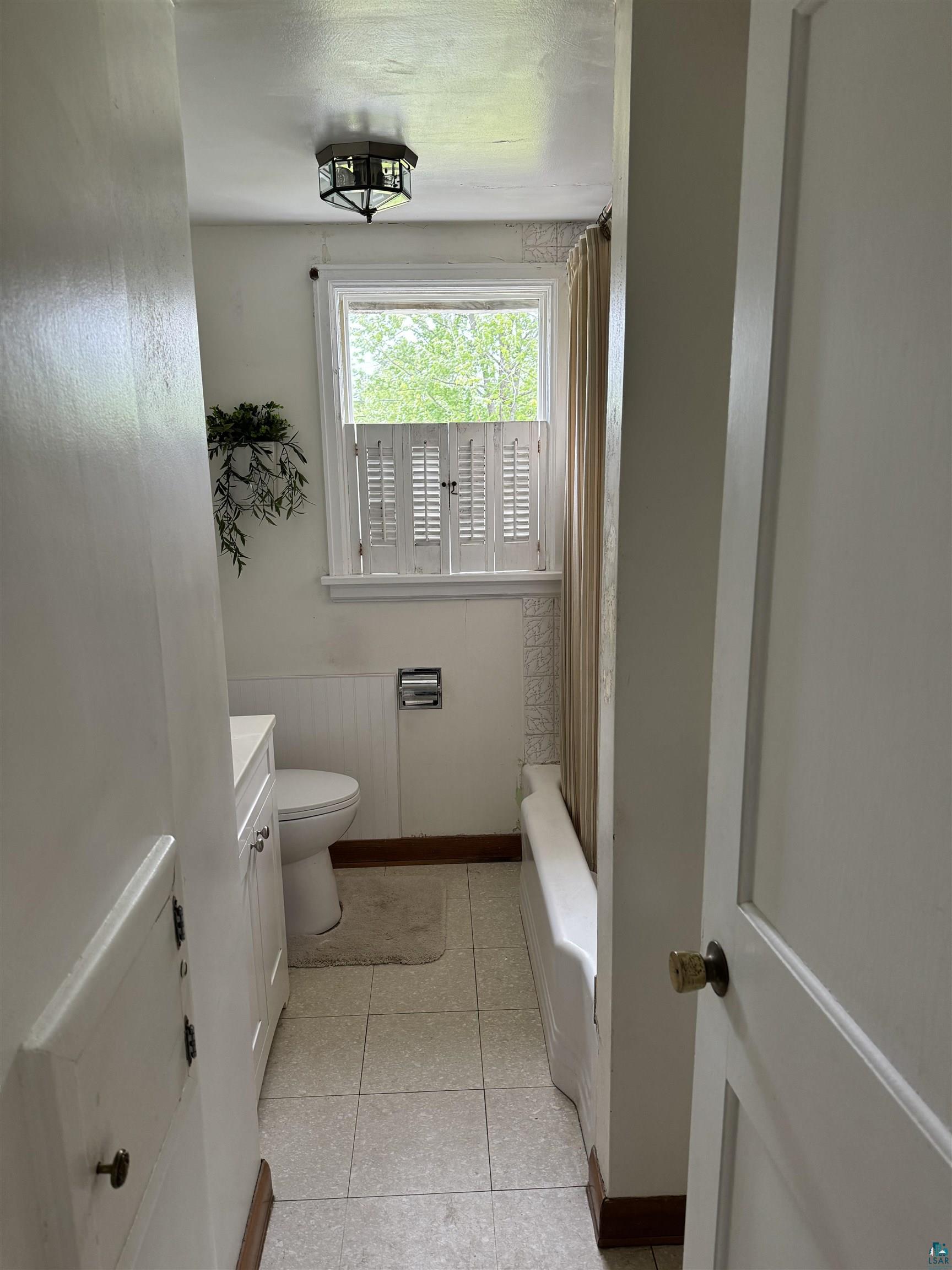 4416 Oneida Street Duluth, MN 55804 - Photo 7 of 12 Full bathroom featuring tile floors, shower / bathtub combination, toilet, and vanity