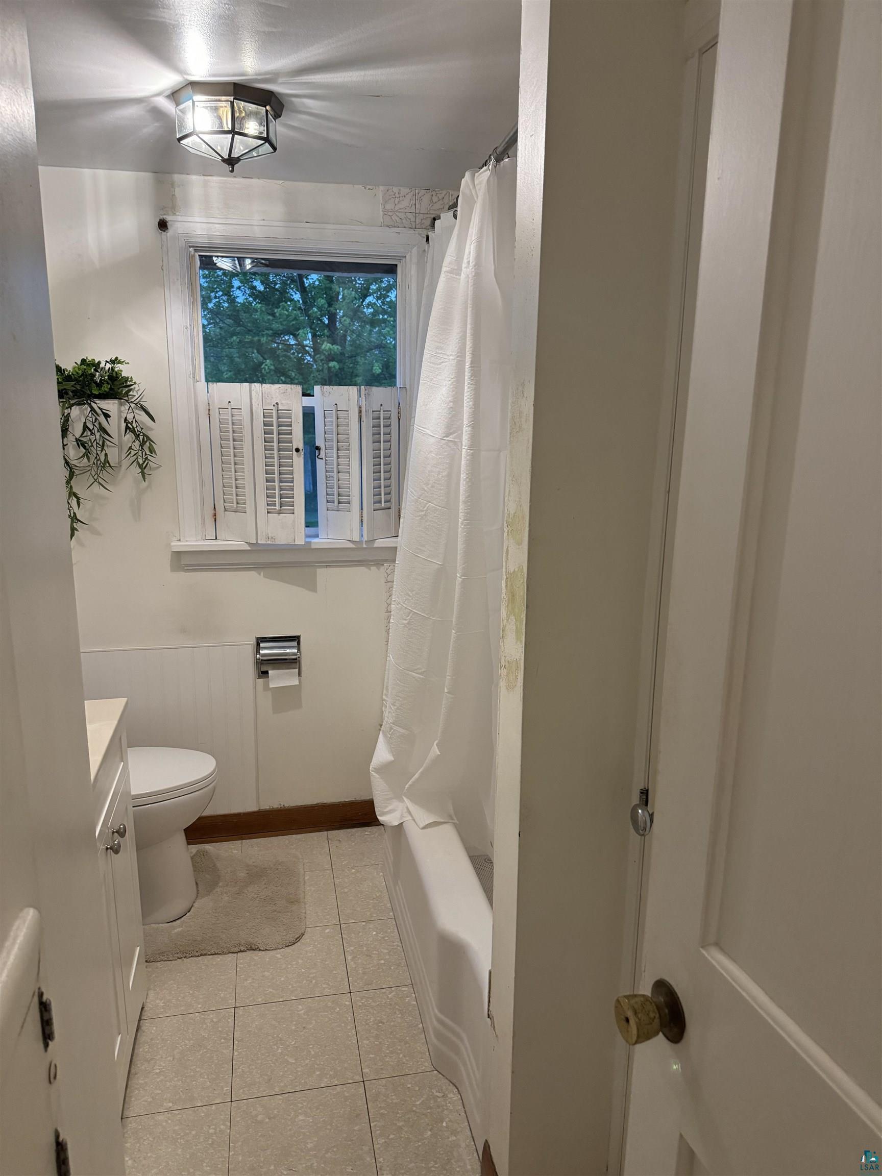 4416 Oneida Street Duluth, MN 55804 - Photo 10 of 12 Full bathroom with tile flooring, shower / bath combo, vanity, and toilet
