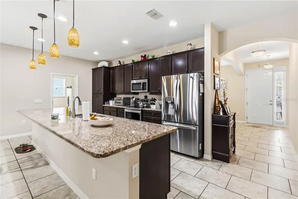 a kitchen with stainless steel appliances granite countertop a refrigerator and a sink