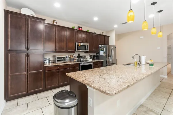a kitchen with stainless steel appliances granite countertop a sink refrigerator and cabinets