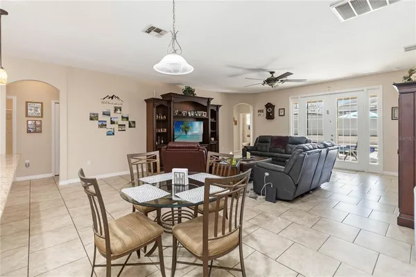 a living room with furniture a dining table and a chandelier