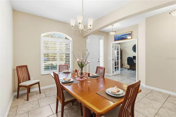 a dining room with furniture a chandelier and window