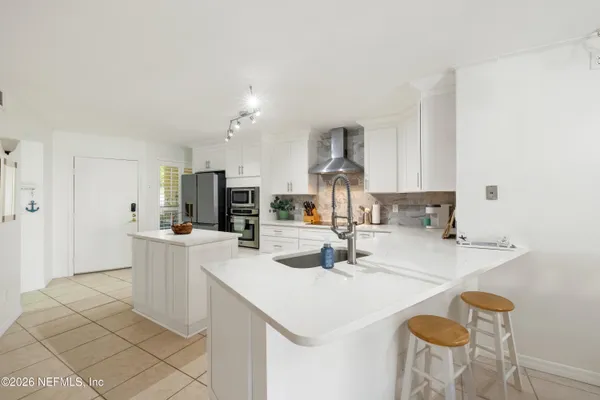 a kitchen with a sink a stove and cabinets