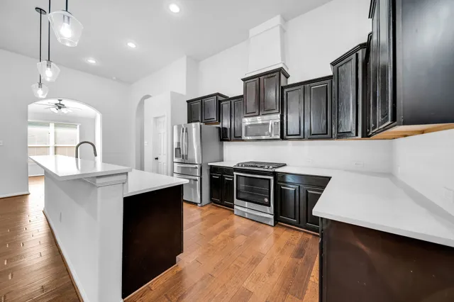a kitchen with stainless steel appliances a sink stove and refrigerator